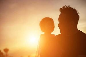 il padre ha preso il bambino impara a camminare al tramonto. foto