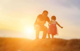 il padre ha preso il bambino impara a camminare al tramonto. foto