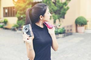 giovane bella donna con fotocamera retrò, ragazza asiatica in stile retrò vintage in vacanza sorridente felice. foto