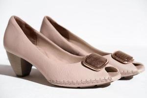 paio di scarpe da donna in pelle naturale. scarpe con tacco medio beige fatte a mano decorate con elementi in legno. concetto di scarpe da donna. pellami di alta qualità e calzature esclusive foto