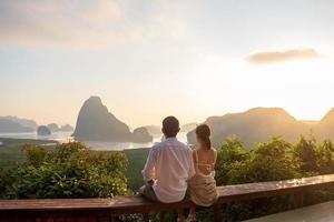 il viaggiatore di coppia felice gode del punto di vista della baia di phang nga, i turisti si rilassano a samet nang lei, vicino a phuket nel sud della tailandia. concetto di viaggio, viaggio, amore, insieme e vacanze estive nel sud-est asiatico foto