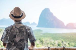 l'uomo viaggiatore felice gode del punto di vista della baia di phang nga, il turista da solo si rilassa a samet nang lei, vicino a phuket nel sud della thailandia. concetto di viaggio, viaggio e vacanze estive nel sud-est asiatico foto