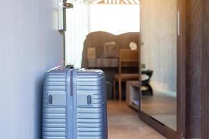 bagagli grigi in una moderna camera d'albergo dopo l'apertura della porta. tempo per viaggiare, viaggio, viaggio e concetti di vacanza foto