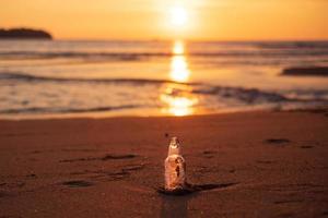 immondizia di bottiglia di vetro sulla spiaggia contro lo sfondo del tramonto. concetto di ecologia, ambiente, inquinamento e problema ecologico foto