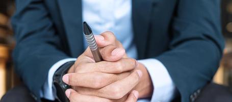 uomo d'affari in giacca e cravatta in ufficio o al bar, mano dell'uomo che tiene durante qualcosa che pensa. concetti di business, decisione e visione foto