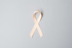 settembre mese di sensibilizzazione sul cancro uterino, nastro color pesca per sostenere le persone che vivono e le malattie. concetto di salute e giornata mondiale del cancro foto