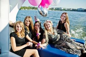 cinque ragazze indossano il nero divertendosi in yacht contro il lago alla festa di addio al nubilato. foto