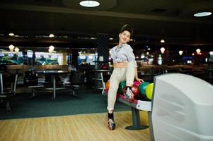 ragazza con palla da bowling sul vicolo giocato al bowling club. foto