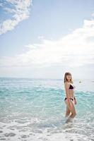 bella modella che si rilassa su una spiaggia vestita con un costume da bagno. foto
