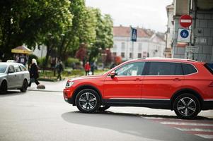 splendida donna alla guida di un'auto suv arancione. foto