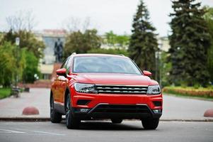 nuova auto suv arancione sulla strada della città. foto