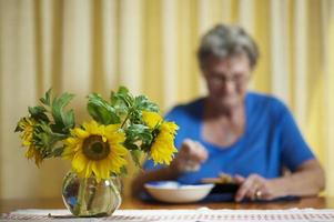 donna anziana che mangia da solo foto