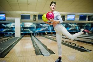 ragazza con palla da bowling sul vicolo giocato al bowling club. foto