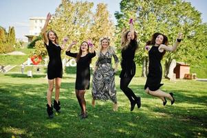 cinque ragazze indossano il nero che salta all'addio al nubilato. foto