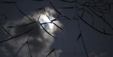 vetro rotto sopra il cielo e il sole dietro lo sfondo della nuvola. foto