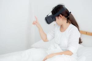 bella giovane donna asiatica allegra e divertente che indossa auricolare per realtà virtuale vr, dispositivo per ragazza e guarda l'intrattenimento del gioco del simulatore in futuro, ricerca femminile con la tecnologia digitale. foto