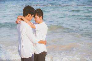 ritratto omosessuale giovane coppia asiatica in piedi abbraccio insieme sulla spiaggia in estate, asia gay turismo per il tempo libero e relax con romantico e felice in vacanza al mare, concetto legale lgbt. foto