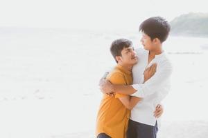 ritratto omosessuale giovane coppia asiatica in piedi abbraccio insieme sulla spiaggia in estate, asia gay turismo per il tempo libero e relax con romantico e felicità in vacanza al mare, concetto lgbt. foto