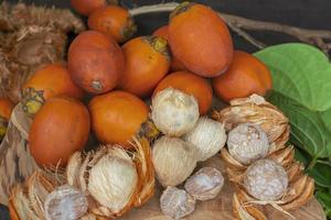 noce di betel matura o noce di areca con foglia di betel isolata su fondo di legno. foto