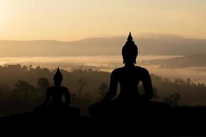 silhouette buddha su sfondo tramonto dorato. foto