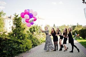 cinque ragazze indossano il nero con palloncini all'addio al nubilato. foto