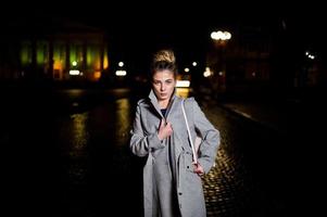 ragazza con i dreadlocks che cammina di notte per la strada della città. foto