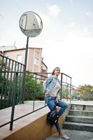ragazza bionda indossa jeans con zaino poste in strada. foto