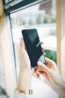 Smart Phone che tiene in mano femminile sullo sfondo blured