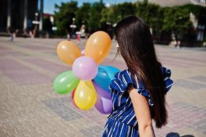 splendida ragazza bruna in strada della città con palloncini a portata di mano. foto