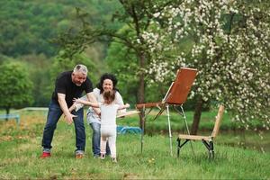 finalmente ci siamo incontrati. nonna e nonno si divertono all'aperto con la nipote. concezione della pittura foto