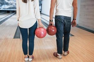 in jeans e camicie bianche. vista ritagliata delle persone al bowling pronte a divertirsi foto