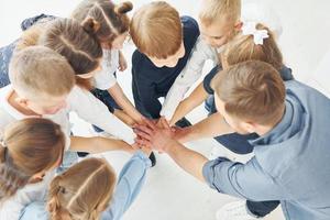 vista dall'alto. uomo con i suoi bambini studenti che si tengono per mano per il successo. concezione dell'educazione foto