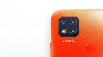 cirebon indonesia, aprile 2022. smartphone arancione del modello redmi 9c con telecamere di intelligenza artificiale isolate su sfondo grigio bianco. adatto per pubblicità aziendale e di settore, ecc. foto