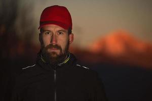 l'uomo guarda l'atleta alpinista con la barba foto