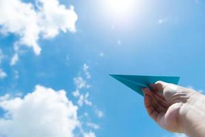 aereo di carta contro il cielo nuvoloso foto