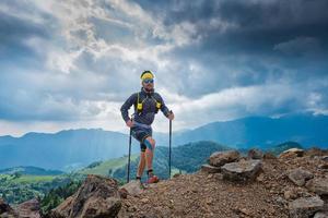 atleta maschio sale su una montagna dietro il panorama delle montagne foto