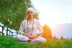 donna yoga sul parco verde foto