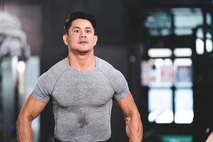 persona forte atleta uomo che si esercita nella palestra sportiva, allenamento di allenamento in fitness per corpo forte e in forma, allenamento di bodybuilding e concetto di stile di vita di persone sane foto