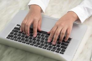 primo piano della mano della donna di affari che scrive sulla tastiera del computer portatile