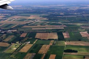 la terra è visibile attraverso il finestrino di un aeroplano foto