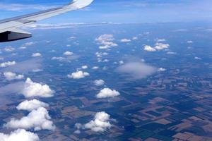 la terra è visibile attraverso il finestrino di un aeroplano foto