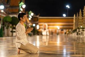 Ritratto giovane asia uomo che indossa abiti tradizionali della Thailandia per rispettare la statua del Buddha a Wat Suthat thepwararam foto