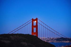 maestoso ponte della baia di san francisco con la luna piena del giugno 2022 che sorge attraverso la torre nord foto