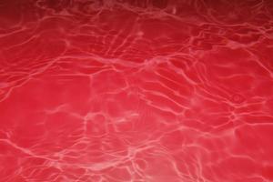 sfocatura sfocato acquerello rosso in piscina increspato acqua dettaglio sfondo. spruzzi d'acqua, sfondo di spruzzi d'acqua. foto