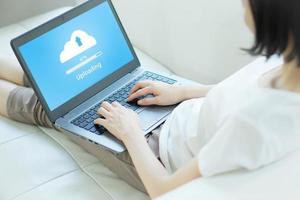 donna che prova a caricare il cloud sul laptop foto