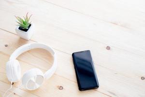 smartphone e cuffie sul tavolo in legno foto
