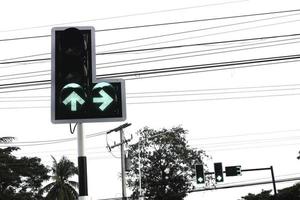 all'incrocio, i semafori verde e rosso indicano che si va dritti o si svolta a sinistra e il bianco o si interrompe la guida. fare attenzione e rispettare le regole del traffico. foto