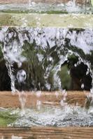 spruzzi di gocce d'acqua e cascata di bolle come sfondo il concetto di freschezza dell'acqua e bolle d'aria sulla superficie dell'acqua. foto