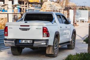 Turchia laterale 18 febbraio 2022 toyota hilux bianca parcheggiata sulla strada in una calda giornata estiva sullo sfondo del mare, hotel foto