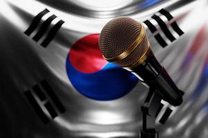microfono sullo sfondo della bandiera nazionale della corea del sud, illustrazione 3d realistica. premio musicale, karaoke, radio e apparecchiature audio per studi di registrazione foto